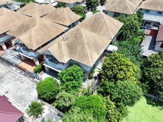 Aerial view of residential neighborhood with tiled roofs and lush greenery