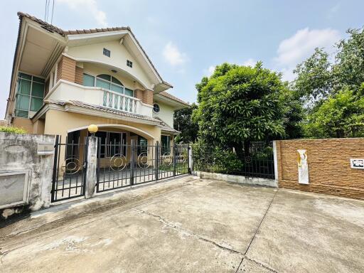 Spacious two-story house with large driveway and lush greenery