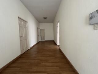 Spacious hallway with wooden flooring and white walls