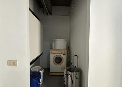 Compact utility room with washing machine and storage space