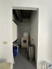 Compact utility room with washing machine and storage space