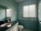 Bright bathroom with teal tiles and modern amenities