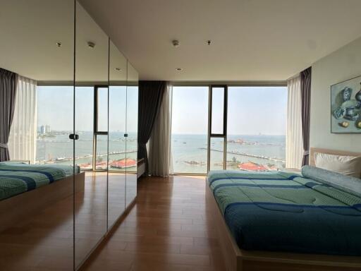 Spacious bedroom with ocean view and wooden flooring