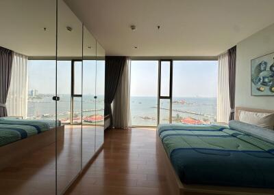 Spacious bedroom with ocean view and wooden flooring