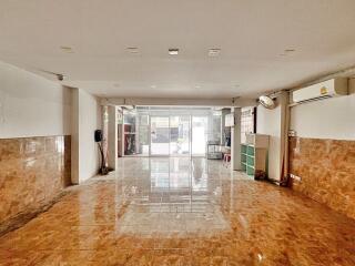 Spacious tiled lobby in a commercial building with large glass doors and natural light