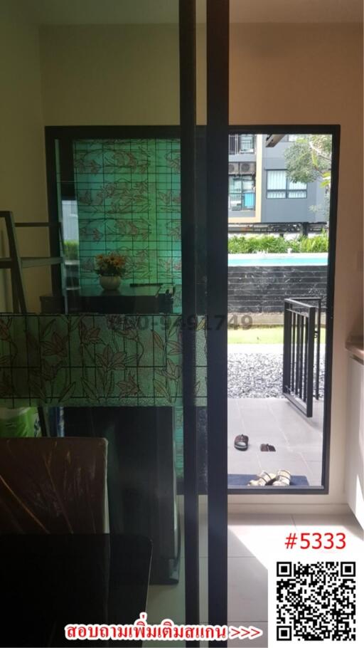 Modern glass door entrance leading to an outdoor garden area