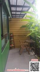 Cozy balcony with wooden furniture and green surroundings