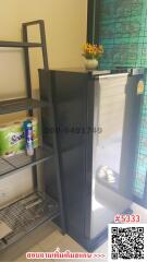 Compact kitchen area with refrigerator and storage shelves