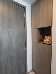 Modern hallway with gray wooden door and built-in cabinets
