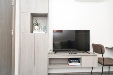 Modern minimalist living room with mounted TV and decorative shelving