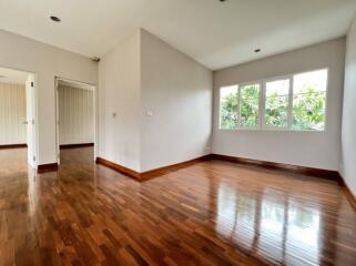 Spacious living room with hardwood floors and large window