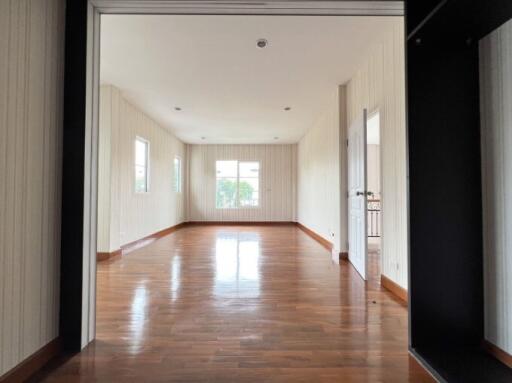 Spacious and bright empty living room with hardwood floors and large windows