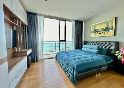 Ocean view bedroom with a large bed and wooden flooring