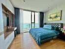 Ocean view bedroom with a large bed and wooden flooring