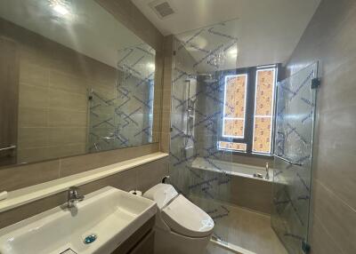 Modern bathroom with reflective shower enclosure and natural light