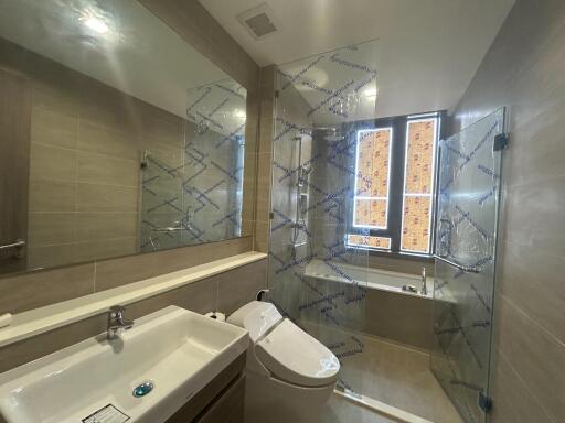 Modern bathroom with reflective shower enclosure and natural light