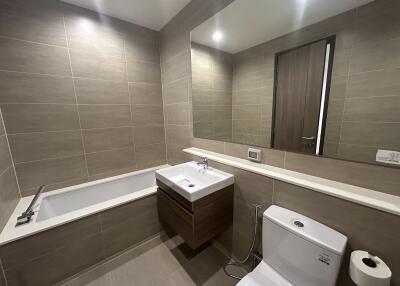 Modern bathroom with clean design featuring a bathtub, sink, toilet, and mirrored cabinet