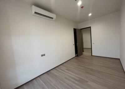 Spacious bedroom with wooden flooring and modern air conditioning unit