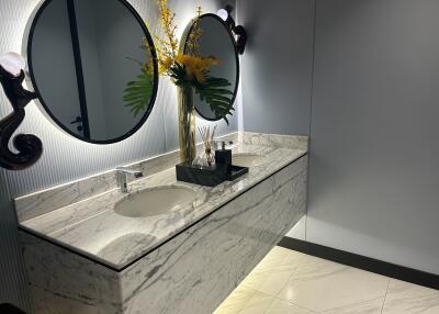 Elegant bathroom with marble countertops and ornate mirror