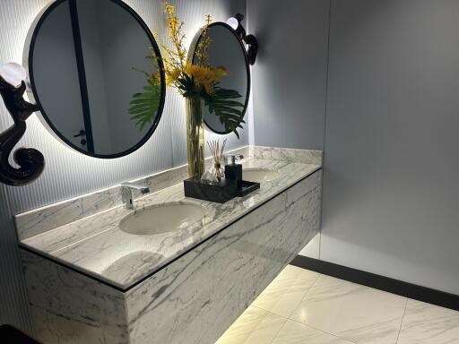 Elegant bathroom with marble countertops and ornate mirror