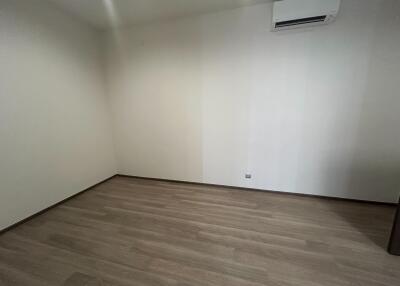 Empty bedroom with wooden flooring and white walls