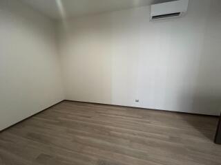 Empty bedroom with wooden flooring and white walls