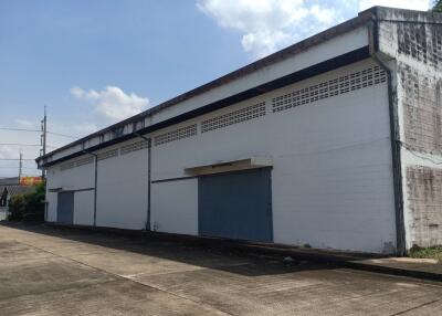 Exterior view of a commercial warehouse with blue roller doors