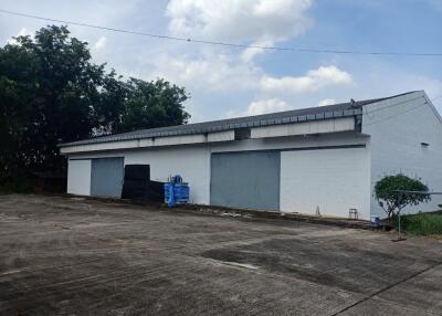 Exterior view of a large storage or industrial building with spacious front parking