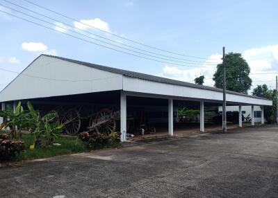 Spacious open garage or storage building with visible carts and serene surroundings