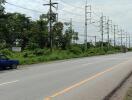 Image of a street scene with electrical power lines and passing vehicles