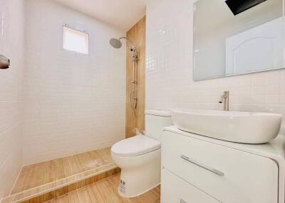 Modern bathroom with white fixtures and wooden accents