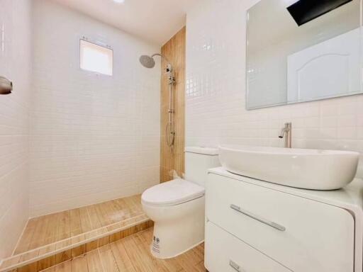 Modern bathroom with white fixtures and wooden accents