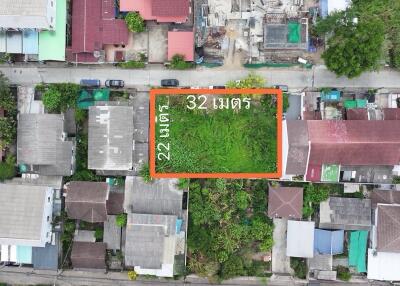 Aerial view of a vacant land plot surrounded by residential buildings