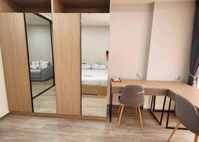 Spacious bedroom with large mirrored wardrobe and study area