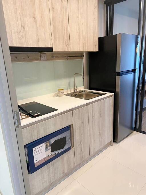Modern compact kitchen with wood finish and built-in appliances