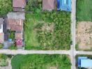 Aerial view of a residential neighborhood showing houses, a road, and green areas