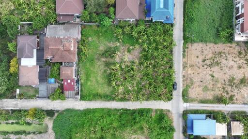 Aerial view of a residential neighborhood showing houses, a road, and green areas