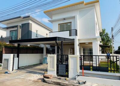 Modern two-storey residential house with a carport and balcony