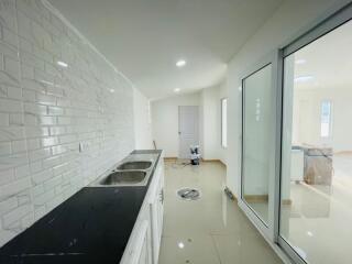 Modern kitchen with white brick wall tiles and black countertop