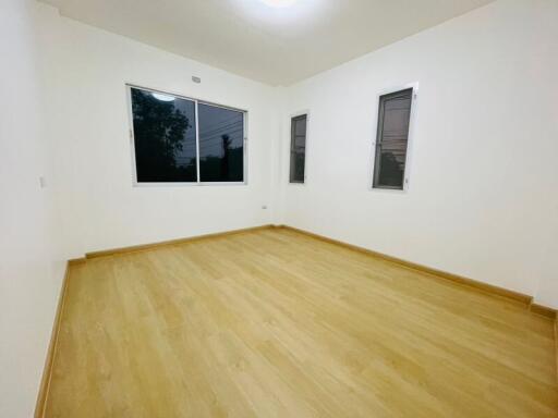 Spacious and well-lit empty bedroom with large windows
