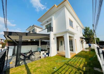 Modern two-story house with lawn and carport