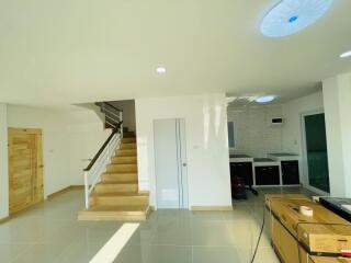 Spacious living room with staircase and modern kitchen