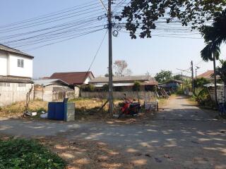 Rural street with houses and parked vehicles