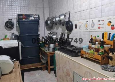 Cluttered small kitchen with various appliances and cookware