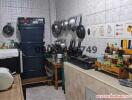 Cluttered small kitchen with various appliances and cookware