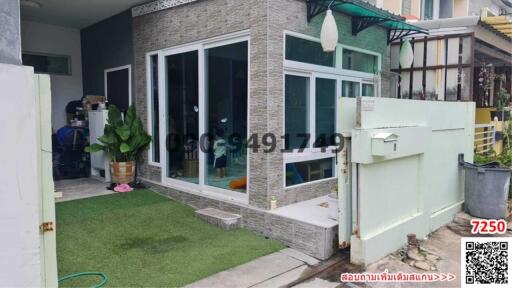 Exterior view of a modern home with large windows and green artificial turf