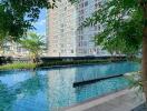 Luxurious outdoor swimming pool with modern high-rise apartment building in the background