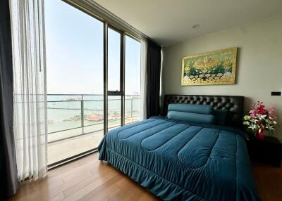 Spacious bedroom with ocean view, king-sized bed, and wooden floor