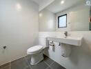 Modern bathroom with white fixtures and gray tiles