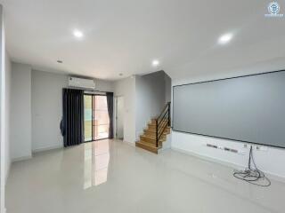 Spacious living room with stairs and large windows